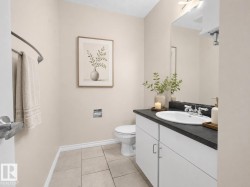 Bathroom featuring a white vanity with a dark countertop, an integrated sink, and chrome fixtures - 