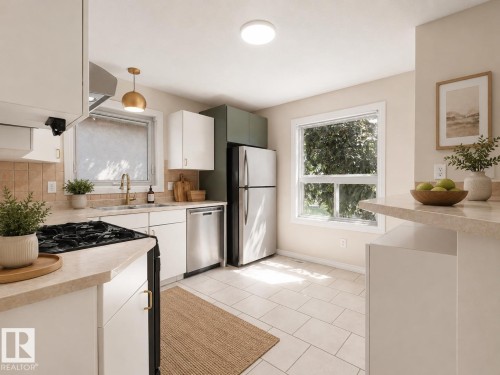 Kitchen featuring light-toned tile flooring, white cabinetry with brass hardware, stainless steel appliances, and a tiled backsplash - 1855 Mill Woods Rd E Nw, Edmonton, AB 
