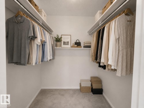 Walk-in closet featuring white walls, gray carpeting, and integrated shelving with hanging rods - 1855 Mill Woods Rd E Nw, Edmonton, AB 