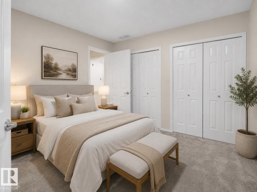 Bedroom featuring neutral wall colors, soft gray carpeting, and multiple white bi-fold closet doors - 1855 Mill Woods Rd E Nw, Edmonton, AB 