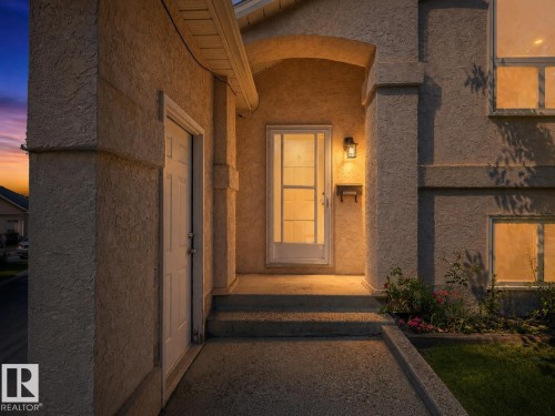 Inviting entryway with a covered porch and textured stucco exterior - 1855 Mill Woods Rd E Nw, Edmonton, AB 