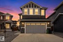 Two-story residence featuring a gray exterior with stone accents and a two-car garage - 714 Ebbers Place, Edmonton, AB 