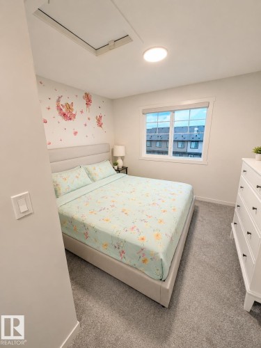 Carpeted room featuring a white-framed window, a flush-mount ceiling light, and light-toned walls - 22845 84 Avenue, Edmonton, AB 
