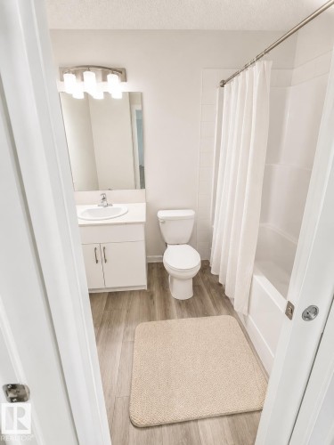 Bathroom featuring a white vanity with integrated sink, chrome faucet, and white cabinetry - 22845 84 Avenue, Edmonton, AB 