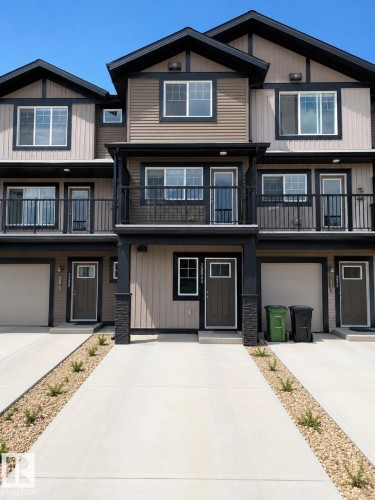Contemporary townhome exterior featuring multi-toned horizontal siding, dark trim, and prominent balconies with black railings - 22845 84 Avenue, Edmonton, AB 