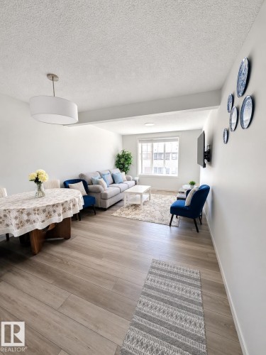 Open-concept living area featuring wood-finish flooring, recessed lighting, and large windows - 22845 84 Avenue, Edmonton, AB 