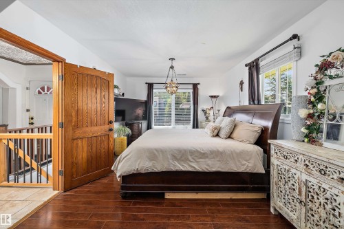 Bedroom with wood-finish flooring, white walls, and a multi-pane window - 11124 110A Avenue Nw, Edmonton, AB 