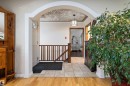 Arched entryway featuring a decorative ceiling, overhead pendant light, and a white paneled door with a transom window - 11124 110A Avenue Nw, Edmonton, AB 