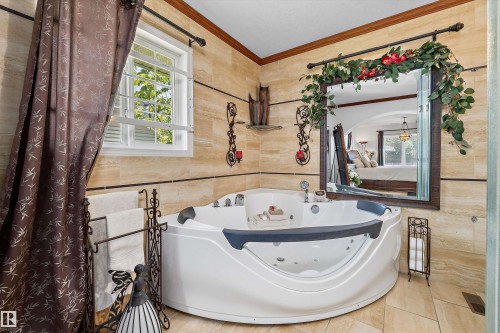 Corner jetted tub featuring a built-in headrest and multiple jets - 11124 110A Avenue Nw, Edmonton, AB 