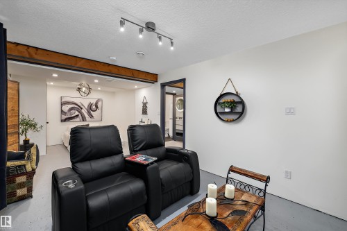 Entertainment space featuring track lighting and a decorative wood beam - 11124 110A Avenue Nw, Edmonton, AB 