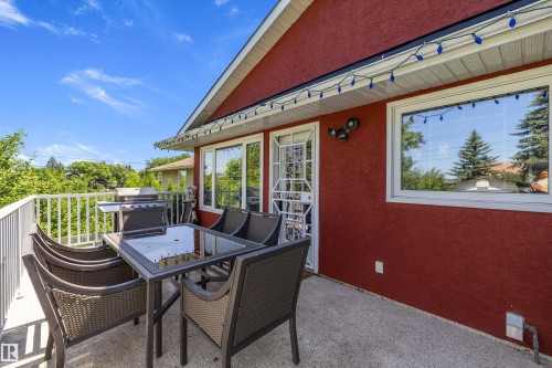 Spacious outdoor concrete deck with white railing, featuring a red stucco exterior, white trim, and ample natural light through large windows - 11124 110A Avenue Nw, Edmonton, AB 