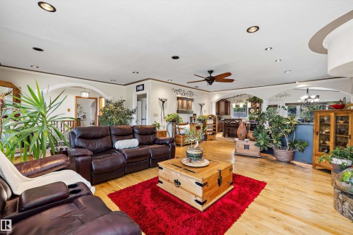 Spacious living area featuring light wood-finish flooring, recessed lighting, and a ceiling fan - 11124 110A Avenue Nw, Edmonton, AB 