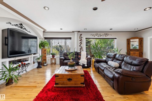 Living room featuring wood-finish flooring, recessed lighting, and a built-in media console with shelving - 11124 110A Avenue Nw, Edmonton, AB 