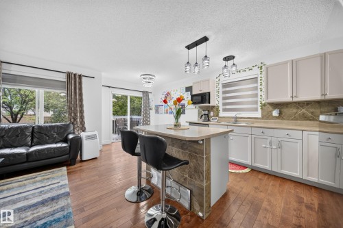 Open-concept kitchen and living area featuring wood-finish flooring - 4 4350 23 Street, Edmonton, AB 