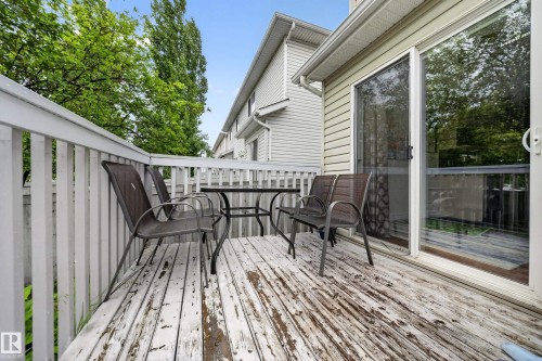 Outdoor deck with white railing, featuring a large sliding glass door - 4 4350 23 Street, Edmonton, AB 
