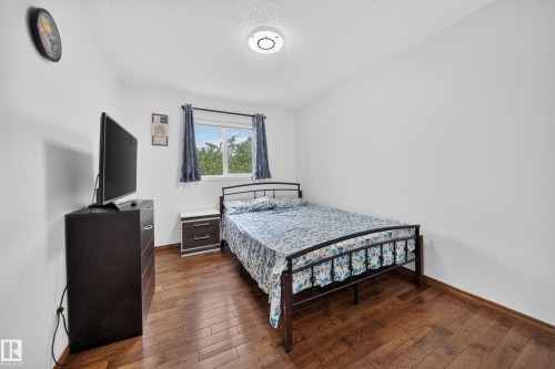 Bright room featuring wood-finish flooring, a white ceiling, and a prominent window - 4 4350 23 Street, Edmonton, AB 