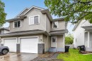 Two-story residence featuring light-toned horizontal siding, a twin garage with white doors, and a covered entry - 4 4350 23 Street, Edmonton, AB 