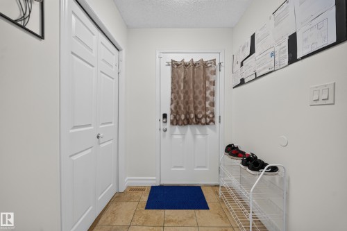 Entryway featuring light-toned tile flooring and white trim - 4 4350 23 Street, Edmonton, AB 
