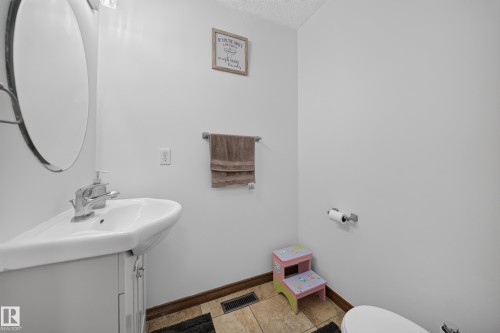 Vanity with integrated white sink, chrome faucet, and storage cabinet - 4 4350 23 Street, Edmonton, AB 