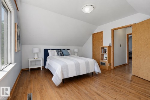 Wood-finish flooring throughout, complemented by sloped ceilings and a flush-mount ceiling light fixture - 11619 122 Street, Edmonton, AB 