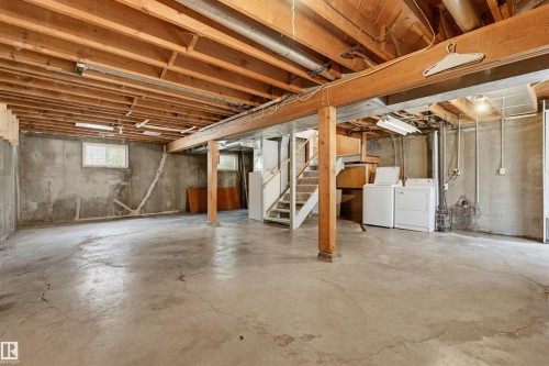 Spacious unfinished basement offering exposed wood joists, concrete flooring, and multiple windows - 11619 122 Street, Edmonton, AB 