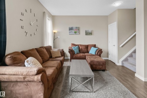 Living area featuring light neutral wall tones and wood-finish flooring - 13 2803 James Mowatt Trail, Edmonton, AB 
