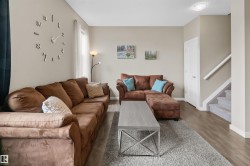 Living area featuring light neutral wall tones and wood-finish flooring - 