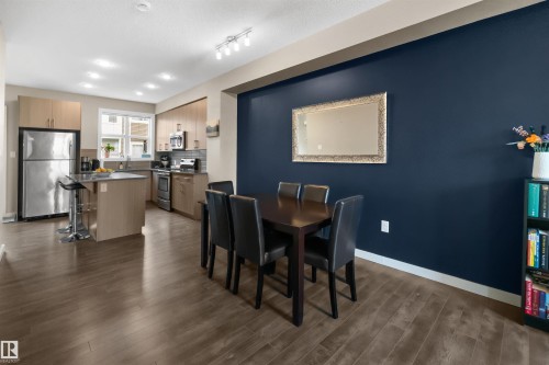 Open-concept kitchen and dining area with wood-finish flooring - 13 2803 James Mowatt Trail, Edmonton, AB 