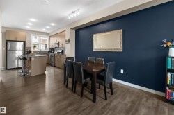 Open-concept kitchen and dining area with wood-finish flooring - 