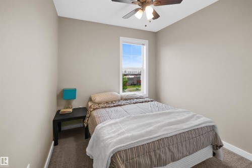 Bedroom featuring neutral wall tones, a single window with white trim, and a ceiling fan with integrated lighting - 13 2803 James Mowatt Trail, Edmonton, AB 