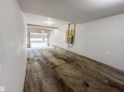 Spacious garage with a concrete floor, painted walls, overhead lighting, and an accessible electrical panel - 