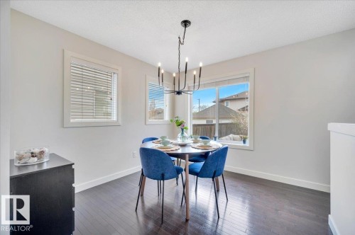 Dining area featuring dark wood-finish flooring and a contemporary chandelier - 4865 Terwillegar Common, Edmonton, AB - Indoor Photo Showing Dining Room
