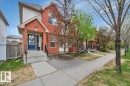 Red brick and siding exterior featuring a covered porch, concrete steps and black metal railings - 4865 Terwillegar Common, Edmonton, AB  - Outdoor With Facade 