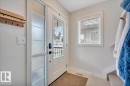 Entryway featuring a white paneled door with glass inserts, a frosted glass sidelight, and a built-in wall-mounted coat rack - 4865 Terwillegar Common, Edmonton, AB  - Indoor Photo Showing Other Room 