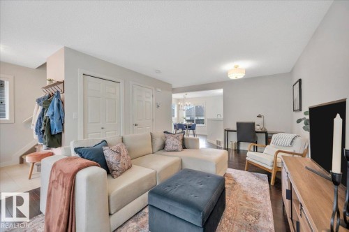 Spacious living area featuring dark wood-finish flooring and light gray wall tones - 4865 Terwillegar Common, Edmonton, AB - Indoor Photo Showing Living Room