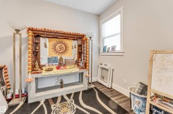 Neutral-toned room featuring wood-finish flooring and a single window with horizontal blinds - 