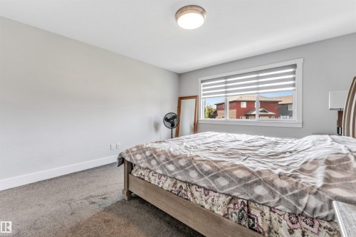 Carpeted room featuring light gray walls, a window with horizontal blinds, white trim, and a flush-mount ceiling light - 8516 216 Street, Edmonton, AB 