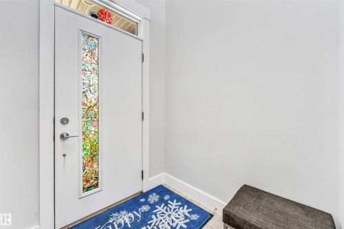 Entryway featuring a white door with a stained glass panel and a transom window - 8516 216 Street, Edmonton, AB 