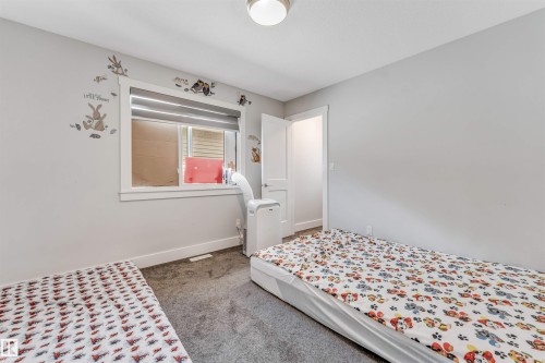 Carpeted room with a window featuring horizontal blinds - 8516 216 Street, Edmonton, AB 