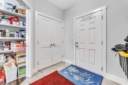 Entryway featuring a paneled door with brushed nickel hardware, light gray walls, and light wood-finish flooring - 