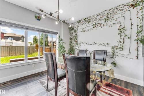 Dining area featuring wood-finish flooring and a large picture window - 8516 216 Street, Edmonton, AB 