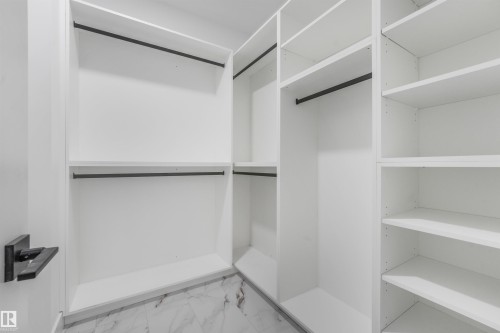 Custom closet system featuring white shelving, black hanging rods, and marble-look tile flooring - 1180 Genesis Lake Boulevard, Stony Plain, AB 