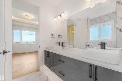 Dual vessel sinks with matte black fixtures, set on a white countertop with a high-gloss gray vanity - 