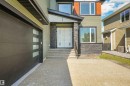 Contemporary exterior featuring olive siding, stone accents, and an orange upper panel - 1180 Genesis Lake Boulevard, Stony Plain, AB 