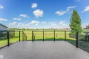 Spacious outdoor deck with a textured dark gray surface, clear glass railings, and black metal posts - 1180 Genesis Lake Boulevard, Stony Plain, AB 