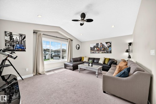 Spacious living area featuring vaulted ceilings, recessed lighting, a large picture window, and neutral-toned wall paint - 13724 166 Avenue Nw, Edmonton, AB 