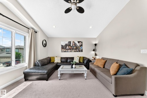 Spacious living area featuring neutral carpet flooring, recessed lighting, and a ceiling fan - 13724 166 Avenue Nw, Edmonton, AB 