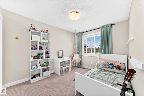 Carpeted room featuring a large window with blinds and drapes, white baseboards, and a ceiling-mounted light fixture - 13724 166 Avenue Nw, Edmonton, AB 