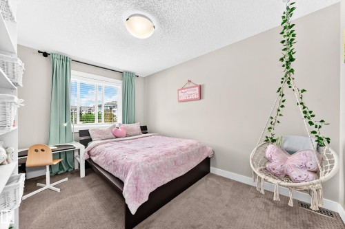 Carpeted bedroom featuring a large window with blinds, ceiling-mounted light fixture, and neutral wall paint - 13724 166 Avenue Nw, Edmonton, AB 