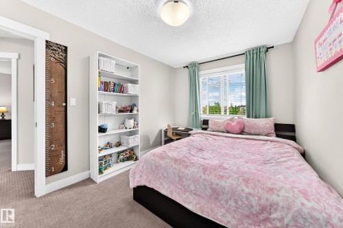 Bedroom featuring neutral wall paint, light-colored carpeting, a window with blinds and drapes, and a ceiling-mounted light fixture - 13724 166 Avenue Nw, Edmonton, AB 